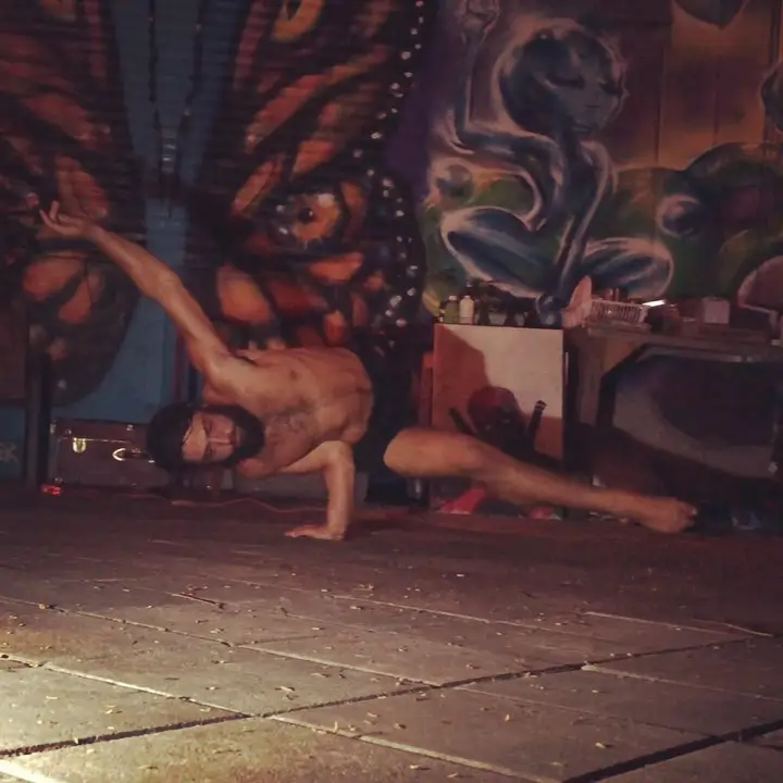 One-arm handstand in front of a mural